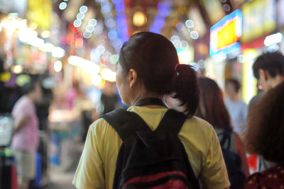 Rear view of people looking at illuminated city at night