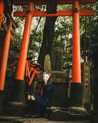 Full length of man sitting on metal structure