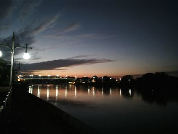 Illuminated pier against sky at night