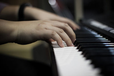 Cropped hands of person playing piano