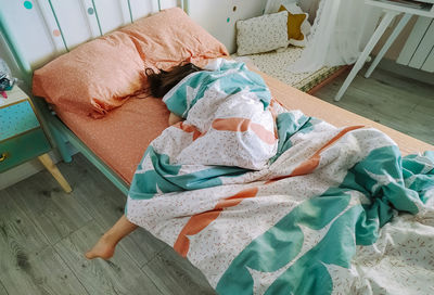 High angle view of girl sleeping on bed at home