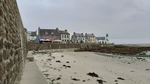 Buildings by sea against clear sky