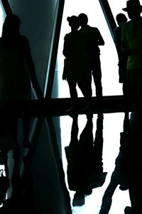 Silhouette people standing on floor against sky