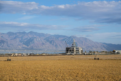 Built structure on land by mountain against sky