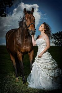 Beautiful bride touching horse