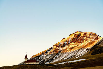 Rock formations by building against clear sky