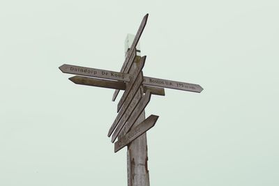 Low angle view of cross sculpture against clear sky