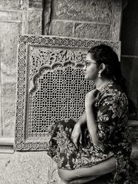 Woman crouching by wall