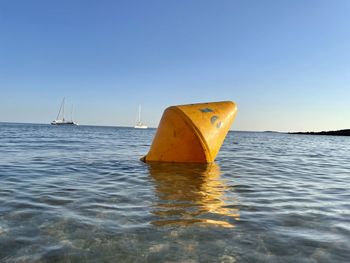 Sailboat in sea against clear sky