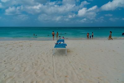 People at beach against sky