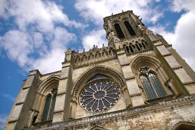 Low angle view of bell tower against cloudy sky