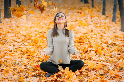 Portrait of young woman sitting on field