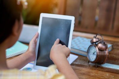 Midsection of woman using mobile phone on table