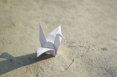 Close-up of paper crane on footpath
