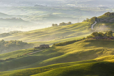 Tuscan farm landscape with morning fog in the valley
