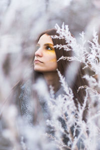 Woman looking way by frozen plants