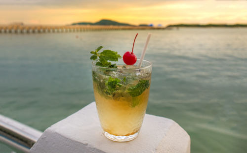 Close-up of drink on lake against sky