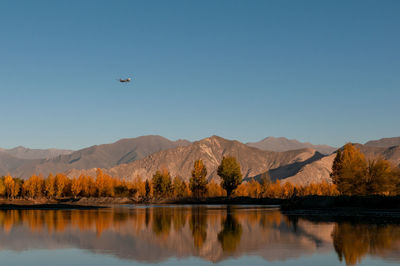 Scenic view of lake and mountains against clear sky