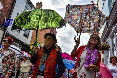 People on multi colored umbrellas against sky