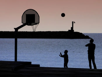 Silhouette basketball hoop against sky during sunset