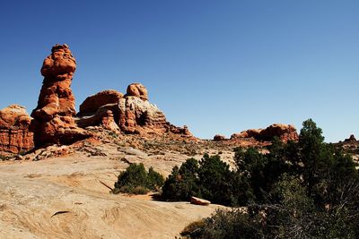 Rock formations on landscape against blue sky