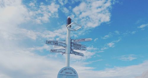 Low angle view of sign against blue sky