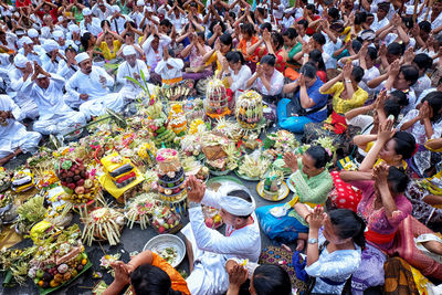 High angle view of people with hands clasped praying outdoors