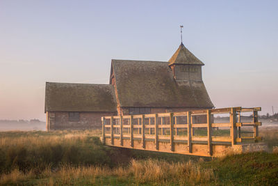 Old building on field against clear sky