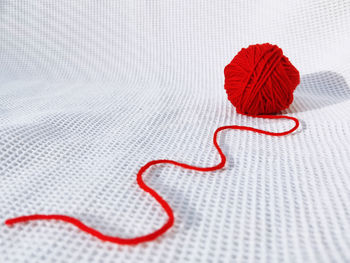 Directly above shot of heart shape made of red paint over white background