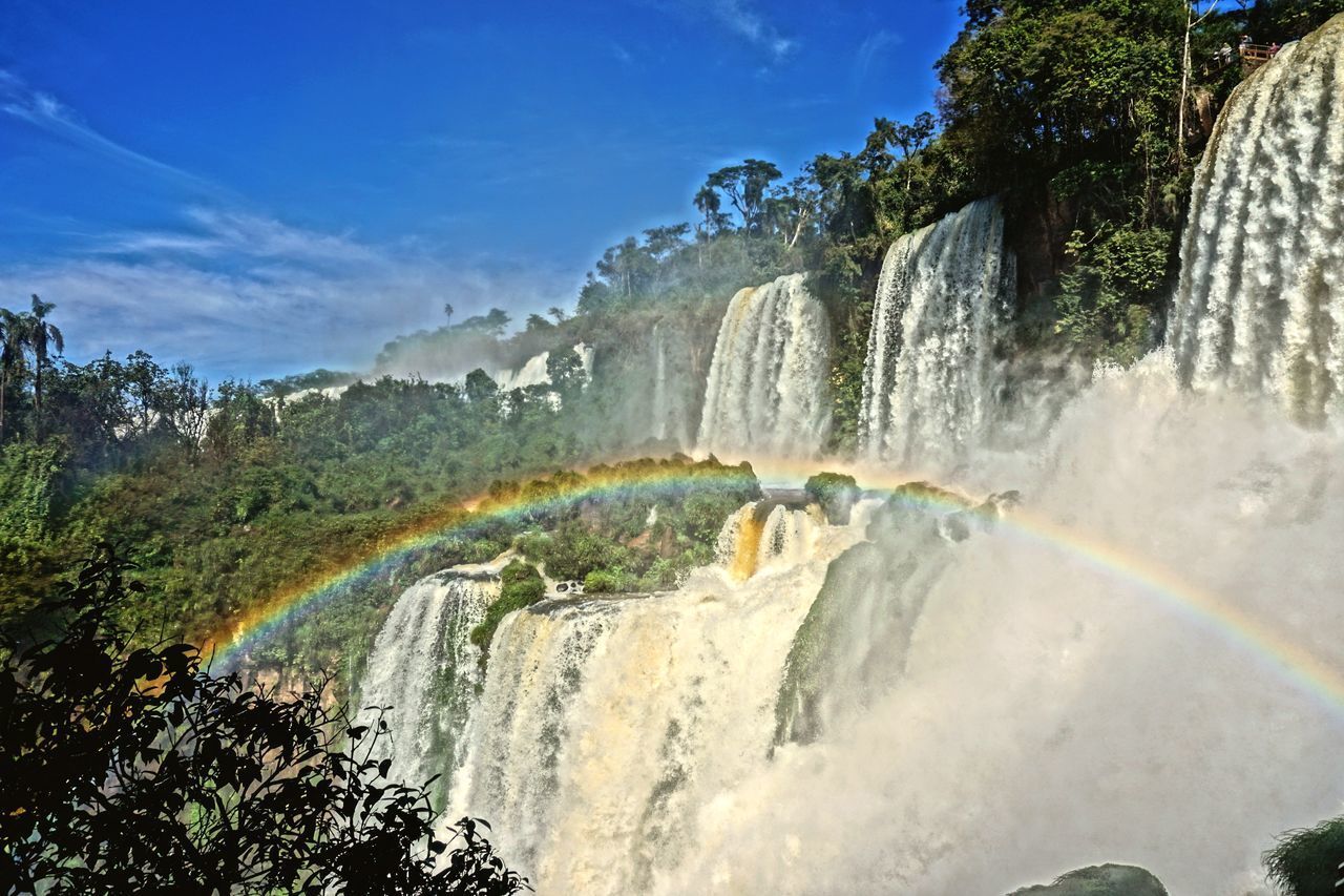 SCENIC VIEW OF WATERFALL AGAINST RAINBOW