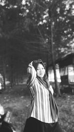 Portrait of woman standing against trees