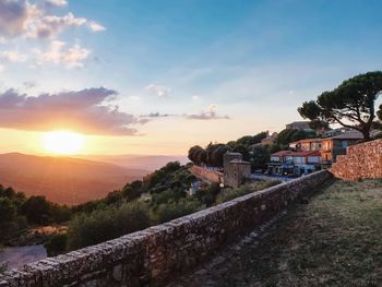 Scenic view of valley and mountains against sky during sunset