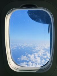 Aerial view of cloudscape seen through airplane window