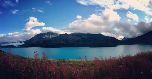 Scenic view of lake by mountains against sky