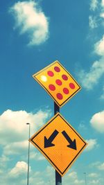 Low angle view of road sign against blue sky