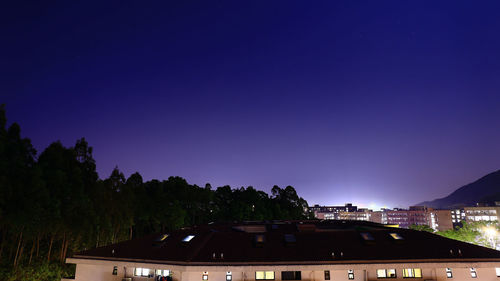 Illuminated building against clear blue sky at night