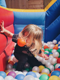 Boy eating ball in colourful ballpit 
