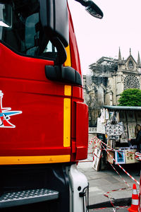 Close-up of red truck in city against the sky