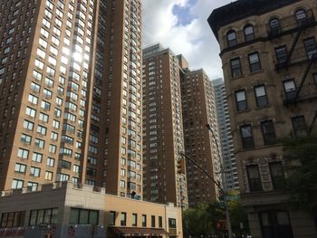 Low angle view of buildings against cloudy sky