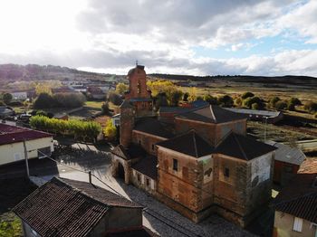 High angle view of old buildings in town against sky