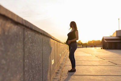 Full length of woman standing on footpath