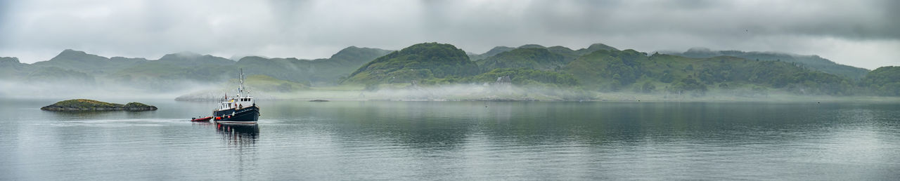 People on boat in river against sky