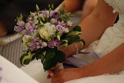 Close-up of hand holding bouquet of red flower