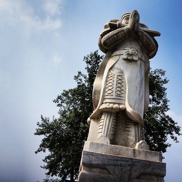 statue, sculpture, low angle view, human representation, art and craft, art, creativity, religion, sky, spirituality, tree, carving - craft product, monument, famous place, place of worship, clear sky, travel destinations