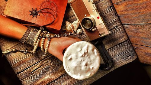 Cropped hand holding drink at table