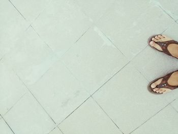 Low section of woman standing on tiled floor