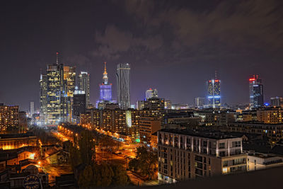 Illuminated buildings against sky at night