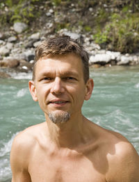 Portrait of smiling mature man against river at whiteswan lake provincial park