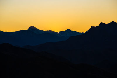 Scenic view of silhouette mountains against sky during sunset