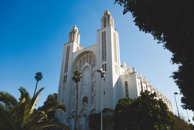 Low angle view of bell tower against clear blue sky